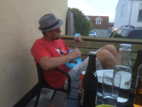 a man in a hat sitting at a table at Lucky 3 Apartments in Løkken