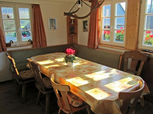 a dining room table with a vase of flowers on it at Ortmanns Eulennest in Finnentrop