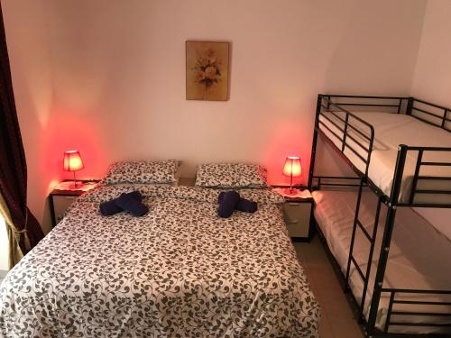 1 dormitorio con 2 literas y 2 lámparas en Swieqi Semi Detached Maisonette, en San Julián