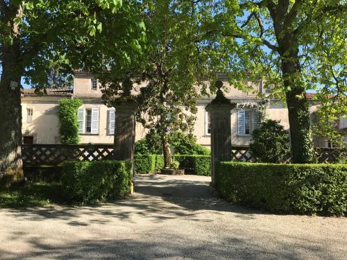um portão em frente a uma casa com árvores em Gite Les Buis de Saint Martin em Marssac-sur-Tarn