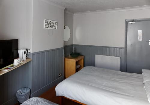 a small bedroom with a bed and a tv at Mallowview guest house in Cleethorpes