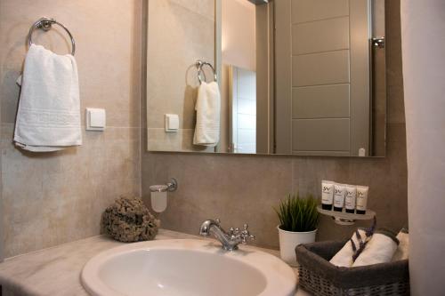 a bathroom with a sink and a mirror at Angelique Apartment in Antiparos