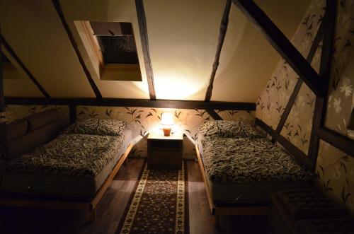 an attic room with two beds and a lamp at Mlýn Isabellental - Isabellino údolí in Stříbro