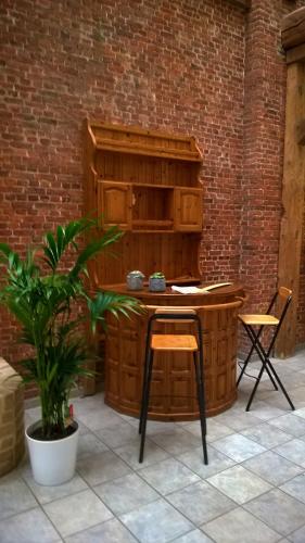 a table and chair in a patio with a brick wall at Condo Gardens Antwerp in Antwerp