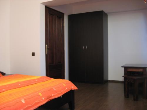 a bedroom with a bed and a black closet at Casa de vacanta Spiritul Deltei in Sfântu Gheorghe
