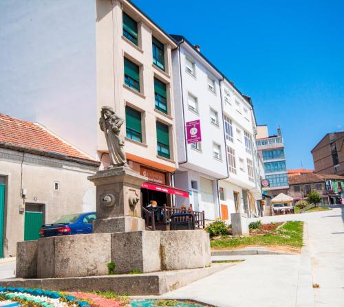 una estatua delante de un edificio en Pension Restaurante Casa Camiño, en Palas de Rei 
