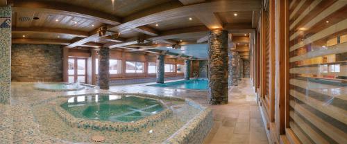 a large indoor swimming pool in a building at CGH Résidences & Spas Le Hameau Du Beaufortain in Les Saisies