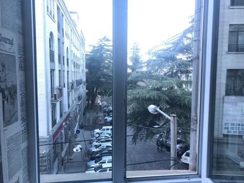 a window with a view of a street with cars at Le Petit in Tbilisi City
