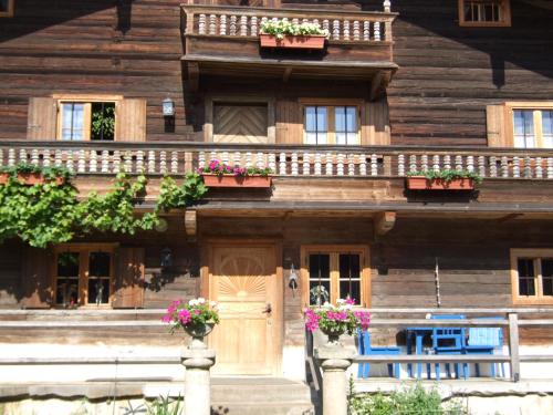 a wooden house with flowerpots on the front of it at Biohof Hausberg in Egglham