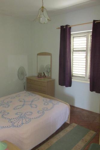 sypialnia z łóżkiem, lustrem i oknem w obiekcie Holiday home w mieście Sušica