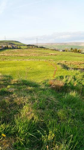 a green field with a fence in the middle of it at Grains Bar Hotel in Oldham
