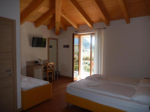 a bedroom with two beds and a sliding glass door at Agritur Giovanazzi in Arco