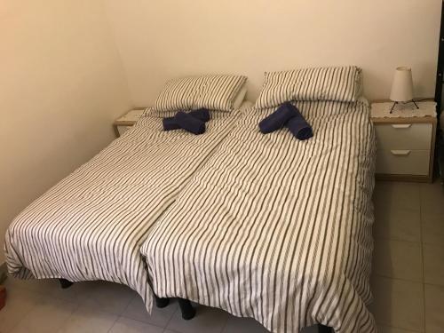 a bed with two blue pillows on top of it at Swieqi Semi Detached Maisonette in St Julian's