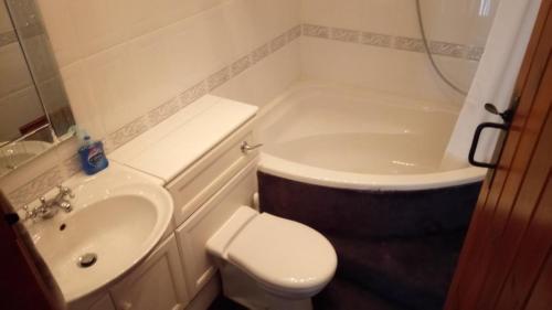 a bathroom with a sink and a toilet and a tub at The Old Swan in Cold Ashton