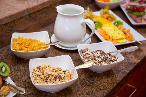 a table topped with bowls of cereal and other food at Kurhotel Roswitha in Bad Wörishofen