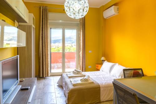 gelbes Zimmer mit einem Bett und einem Fenster in der Unterkunft B-52 Les Roches Noires in Giardini-Naxos