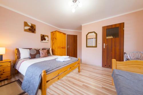 a bedroom with a bed and a table and a mirror at Willa Zacisze in Ustroń