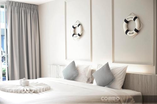 a bedroom with a bed and two towels on the wall at Combo Beach Hotel Samui in Chaweng