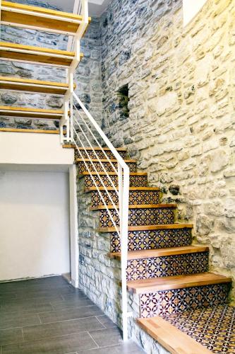 a stone wall with a wooden staircase in a building at Residence San Martino in Erice