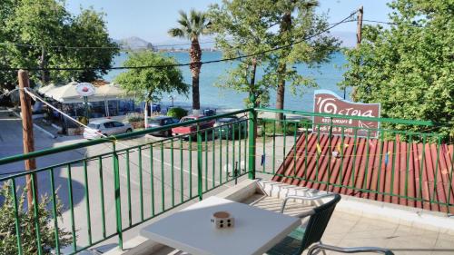 a balcony with a table and a view of the water at Lerna Rooms in Míloi
