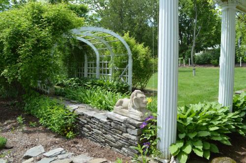 a garden with a statue in a stone wall at The Brewster Inn in Dexter