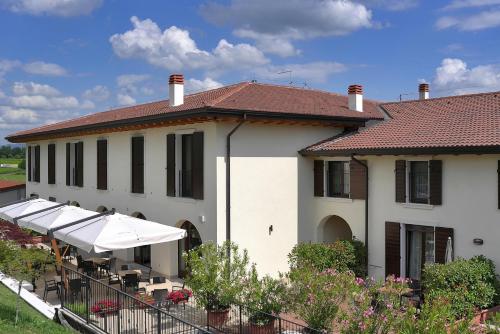 a white house with a table and an umbrella at Agriturismo Le Vai in Bardolino