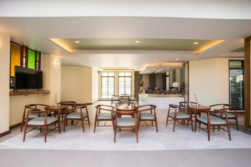 a dining room with wooden tables and chairs at Carunda Hotel Pattaya in Na Jomtien