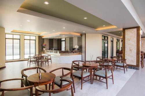 a restaurant with wooden tables and chairs and a counter at Carunda Hotel Pattaya in Na Jomtien