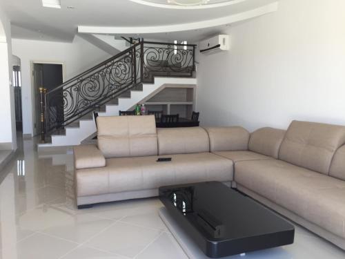 a living room with a couch and a staircase at Belle Villa Avec Piscine sans vis a vis in Midoun