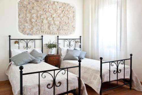 a bedroom with two beds and a chandelier at Agriturismo Prime Gemme in Nervesa della Battaglia