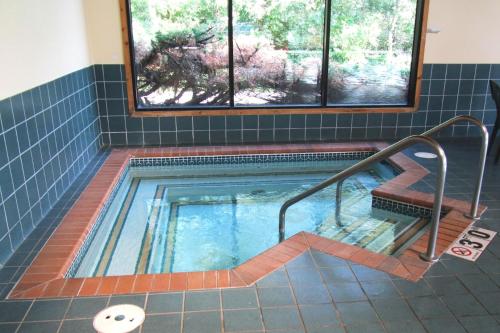 a hot tub in a bathroom with a window at Spring Valley Inn in Spring Green