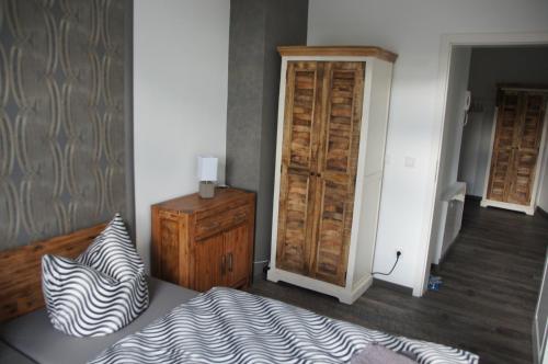 a bedroom with a bed and a dresser with a zebra print pillow at Ferienwohnung Markkleeberg Ost-See in Markkleeberg