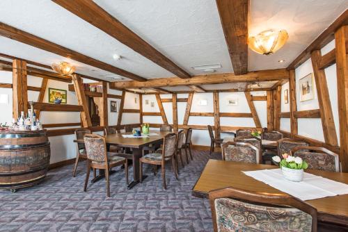 a restaurant with tables and chairs and a barrel at Hotel-Restaurant Weisses Kreuz in Breitenbach