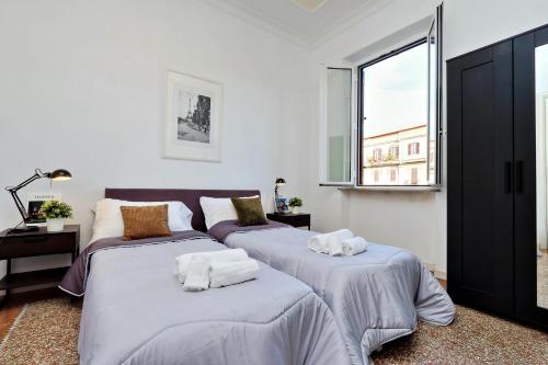 - une chambre avec 2 lits et une fenêtre dans l'établissement Piazza Capponi Apartment, à Rome