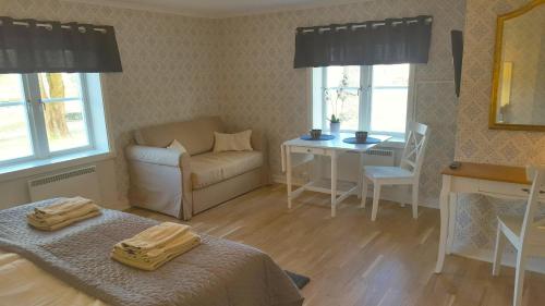 a room with a bed and a chair and a table at Långshyttans Brukshotell in Långshyttan