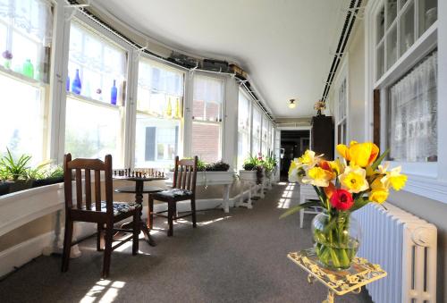 a room with chairs and a vase of flowers on a table at The Brewster Inn in Dexter