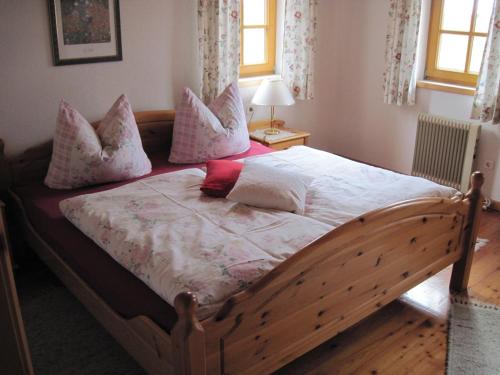 PatergassenにあるFerienwohnung Althoelblingのベッドルーム1室(ピンクと白の枕が備わる木製ベッド1台付)