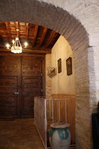 a hallway with an archway in a building with a door at Casa Yedra in Almagro