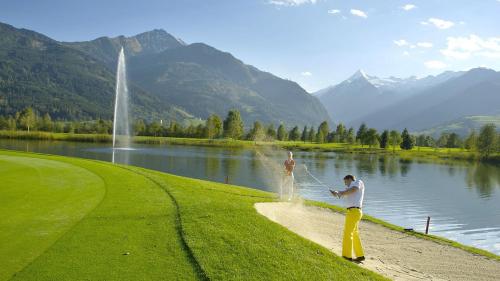 a man is standing on the shore of a lake at Hochleiten-Gut in Niedernsill