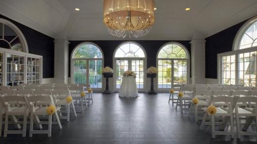 a wedding hall with white chairs and a bride at Ethan Allen Hotel in Danbury