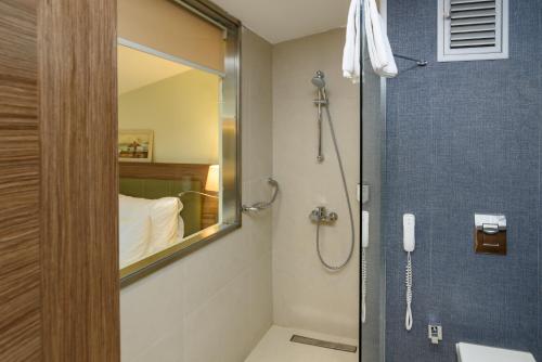 ein Bad mit einer Dusche und einem Spiegel in der Unterkunft Numi Hotel in Istanbul