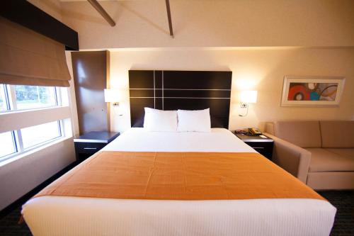 a hotel room with a large bed and a couch at Warehouse Hotel at The Nook in Manheim