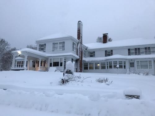 a white house with snow on the ground at The Brewster Inn in Dexter
