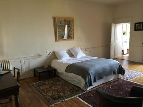 a bedroom with a bed and a table and a window at B&B Le Jardin de Carco in Châtillon-sur-Seine