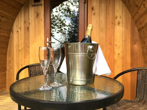 a bottle of champagne in a bucket on a table with glasses at Inglewood House and Spa in Alloa