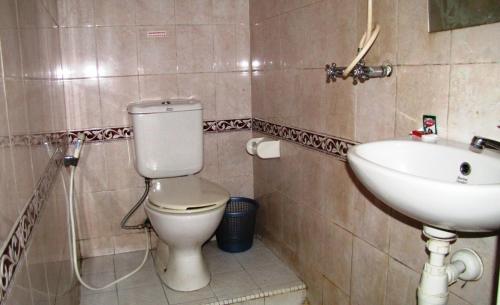 a bathroom with a toilet and a sink at Hotel Mitra Garden in Pangkal Pinang