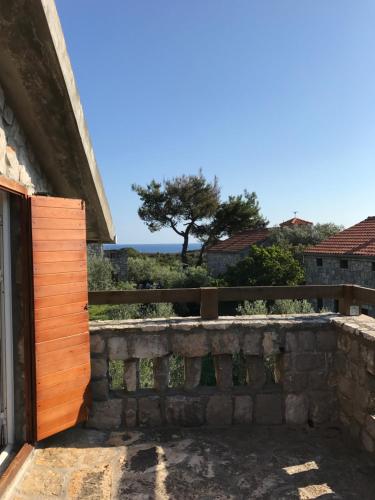 a gate in a stone wall with a tree in the background at Apartments Vuk in Lustica