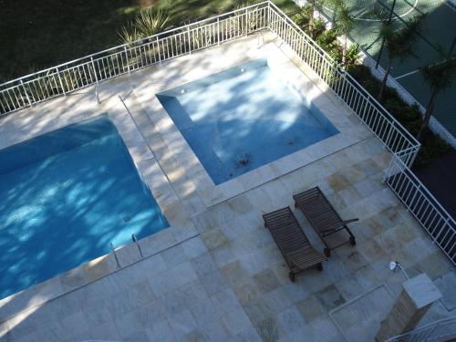 an overhead view of a swimming pool with two chairs at Apartamento Cristal in Porto Alegre