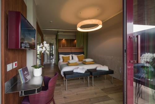 a bedroom with a bed and a table and chairs at Villaverde Hotel Spa&Golf Udine in Fagagna