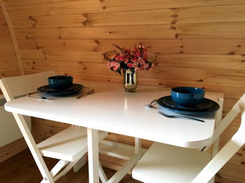 a white table with two chairs and a vase of flowers at Inglewood House and Spa in Alloa
